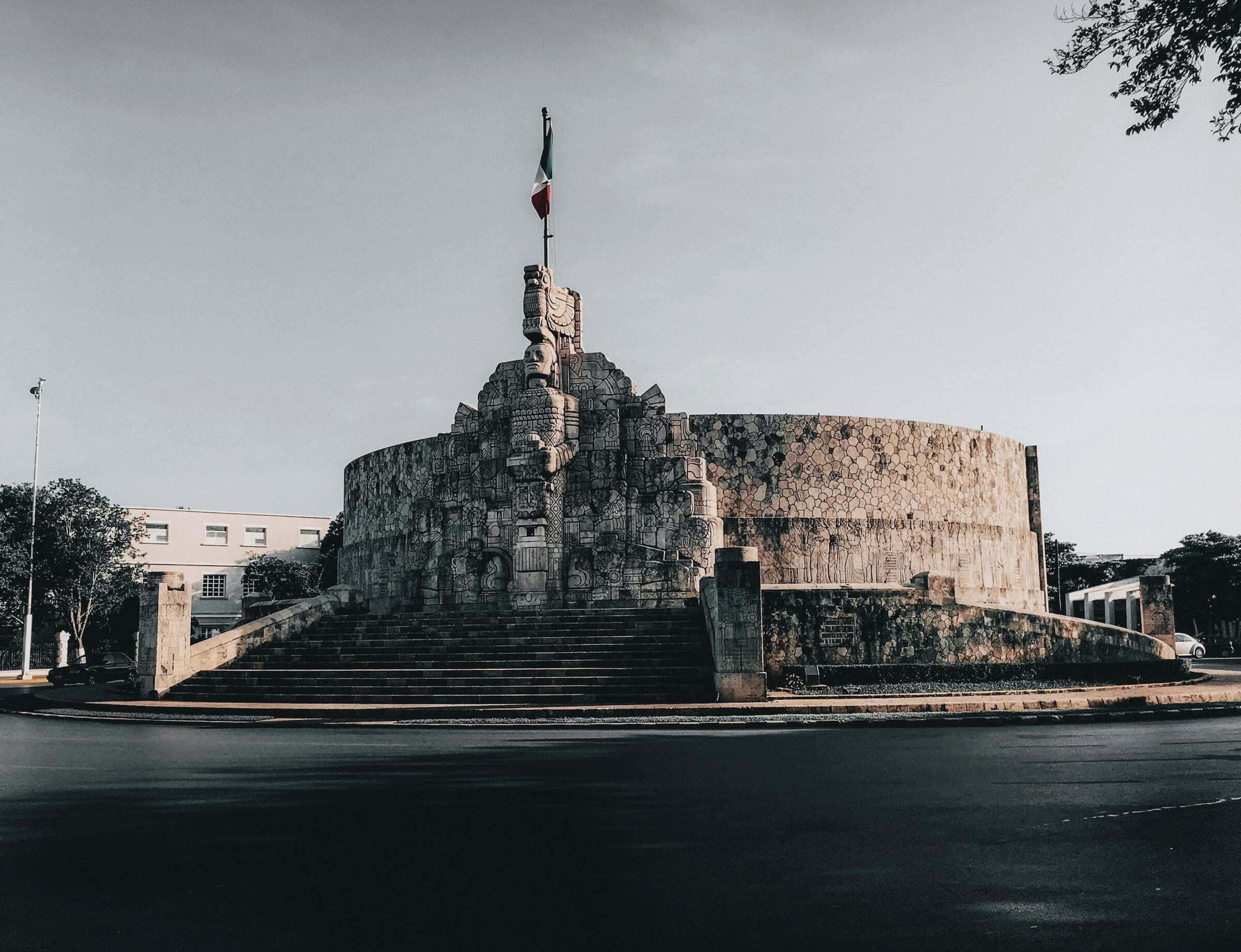 Monumento a la Patria, a carved stone monument with a flag, on a roundabout of Paseo de Montejo in Mérida