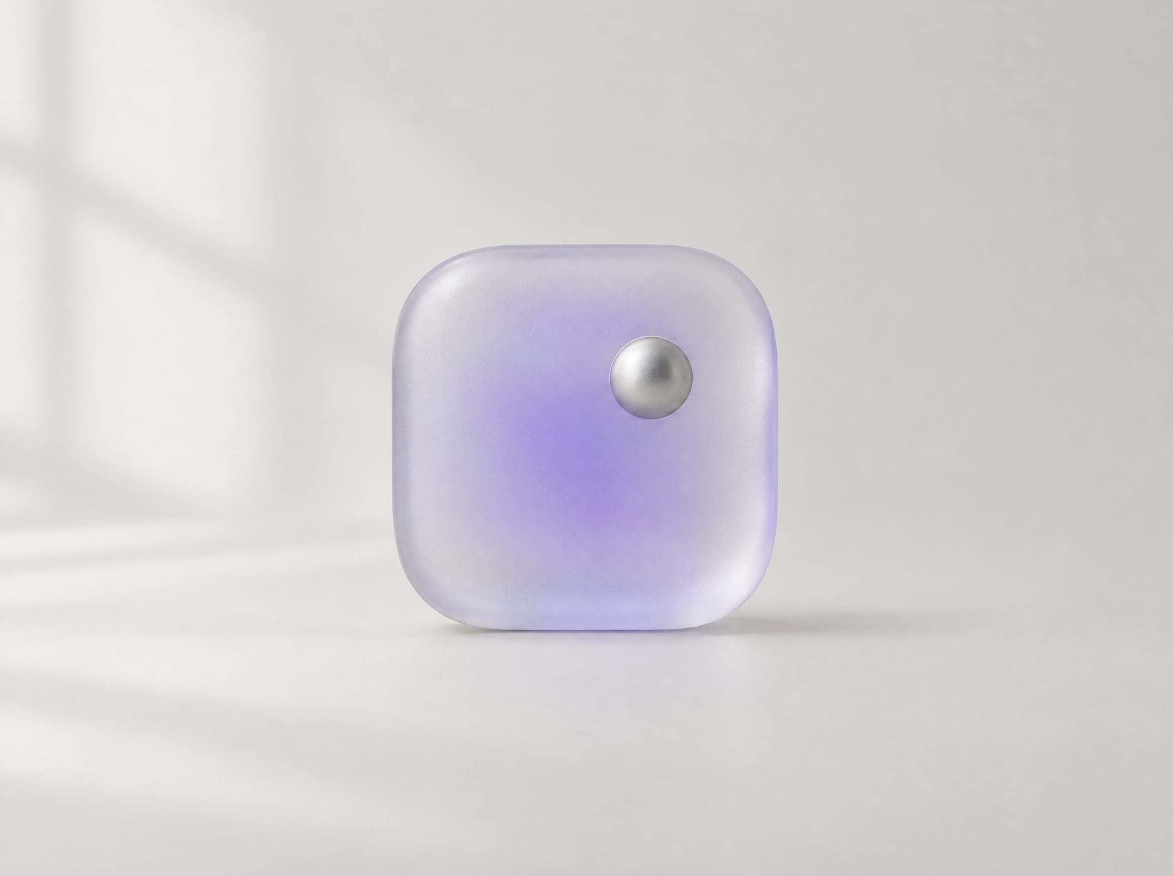A frosted glass squircle with a small aluminum sphere set off-center
