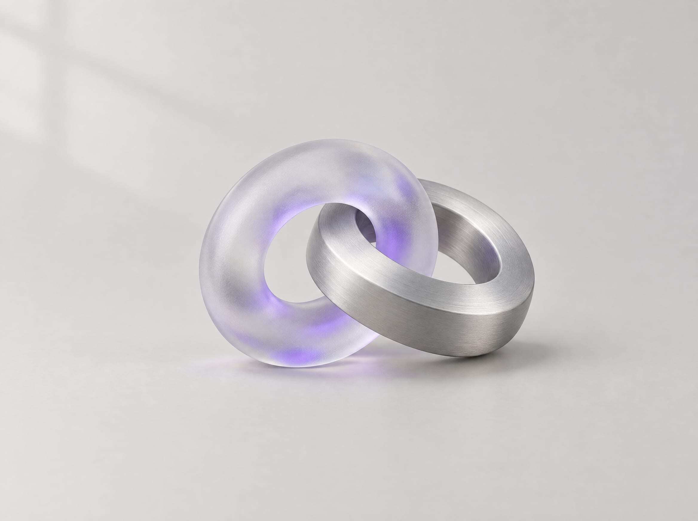 Two interlocking rings of frosted glass and brushed aluminum