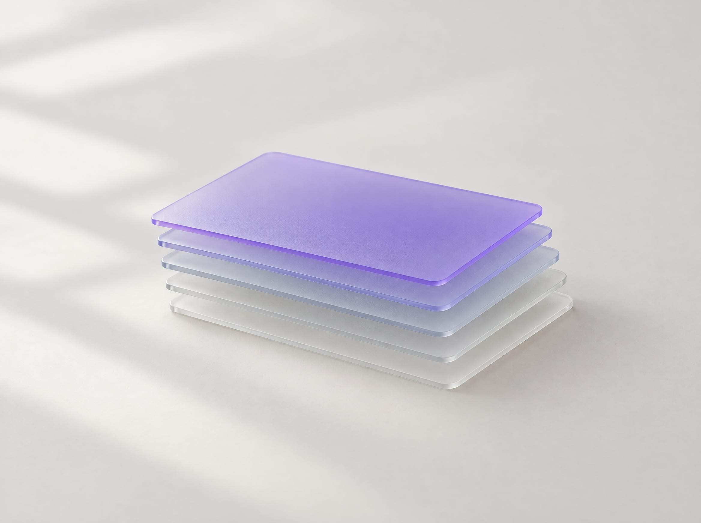 A stack of frosted glass cards, the top one tinted violet
