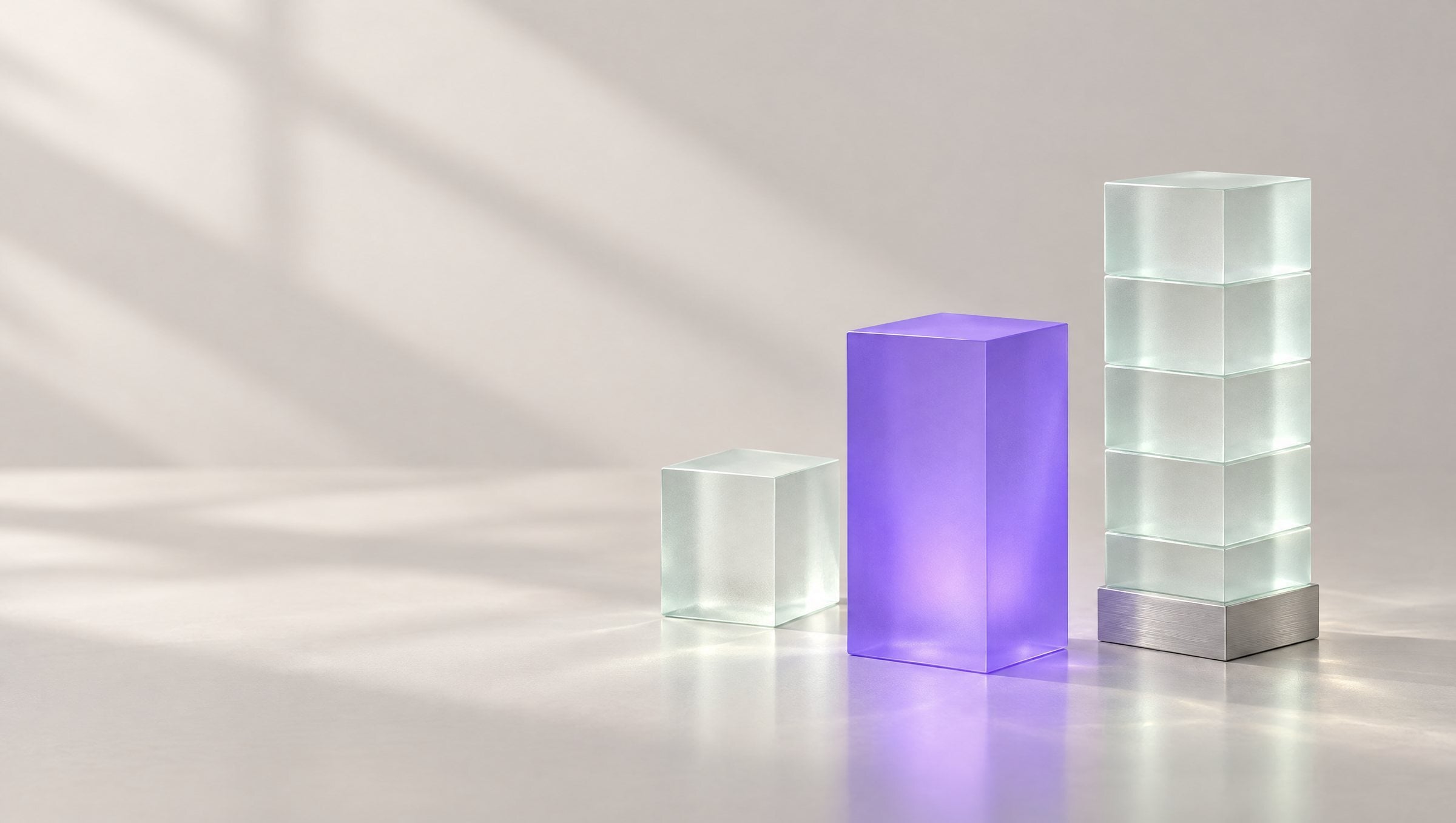 Three frosted glass blocks of increasing size; the violet block in the center glows